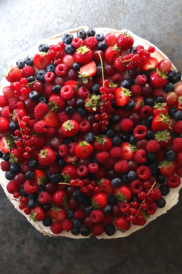 An Italian-style wedding cake – a large, shallow-profile cake, frosted with Swiss meringue buttercream and covered with fresh berries. All ingredients gluten free